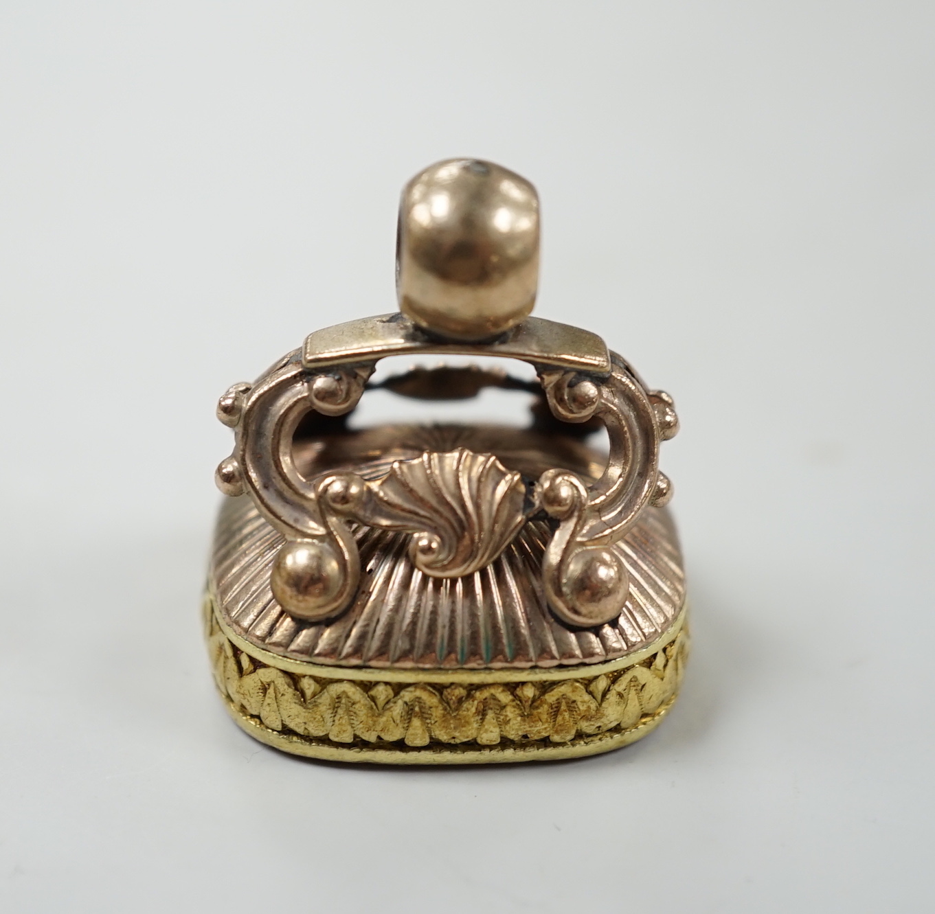 A Georgian yellow metal overlaid and carnelian set fob seal, the matrix carved with a crest, 30mm.